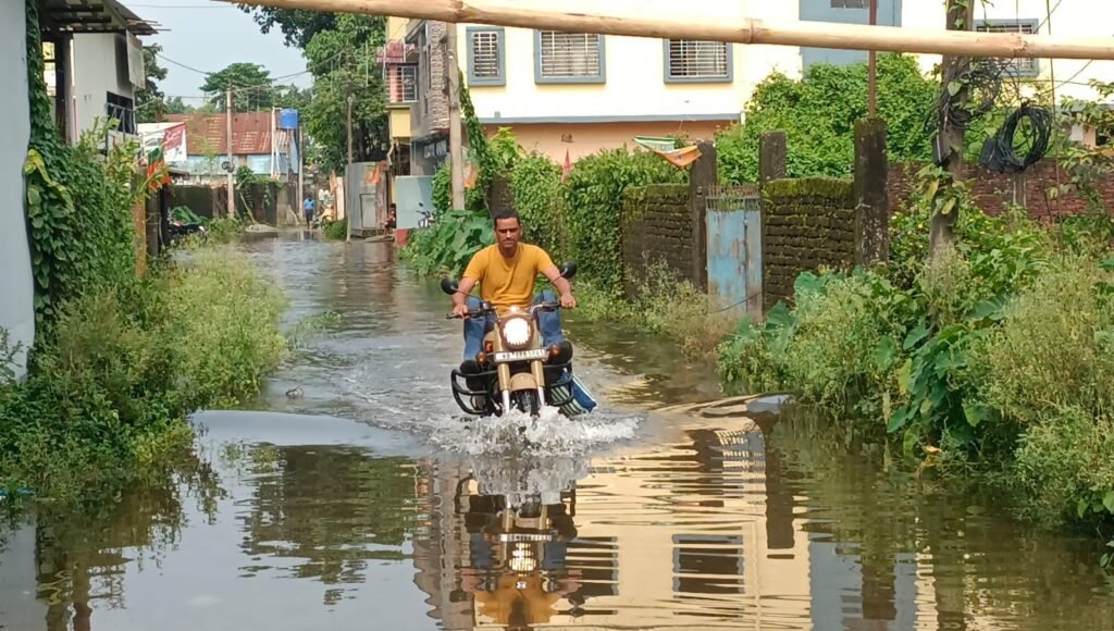 জলমগ্ন এলাকায় বিধায়কের মানবিক উদ্যোগ। নিজেই হাতে আবর্জনার স্তুপ সরিয়ে জল নিষ্কাশনের ব্যবস্থা করে দিল